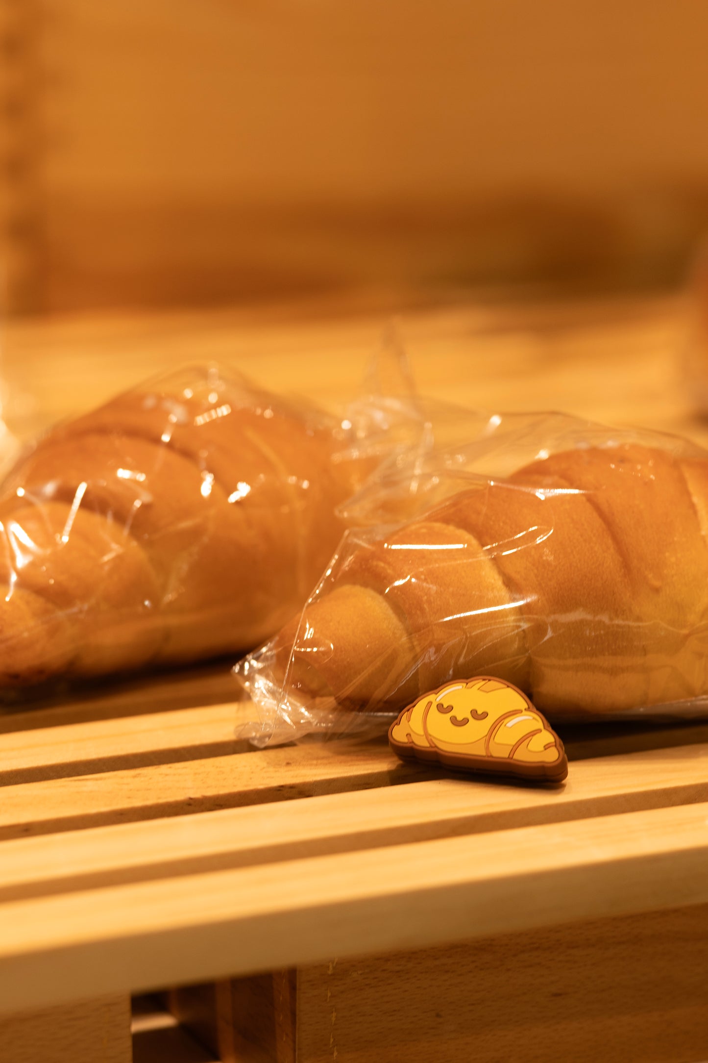 Fun photo of croissant shaped tennis vibration dampener placed on real croissant bread