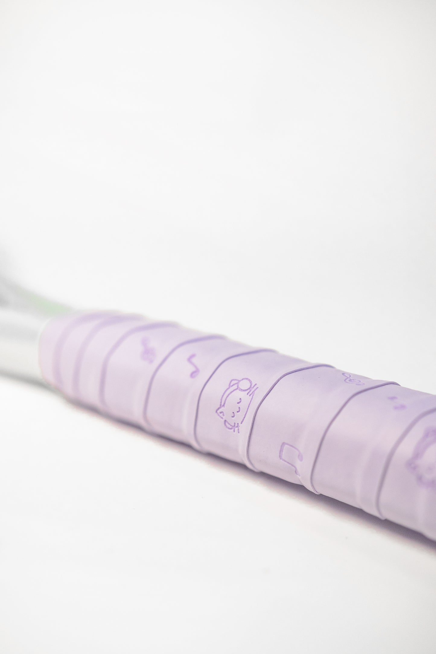 Purple racket grip with playful cat and music note pattern, sticky PU surface.