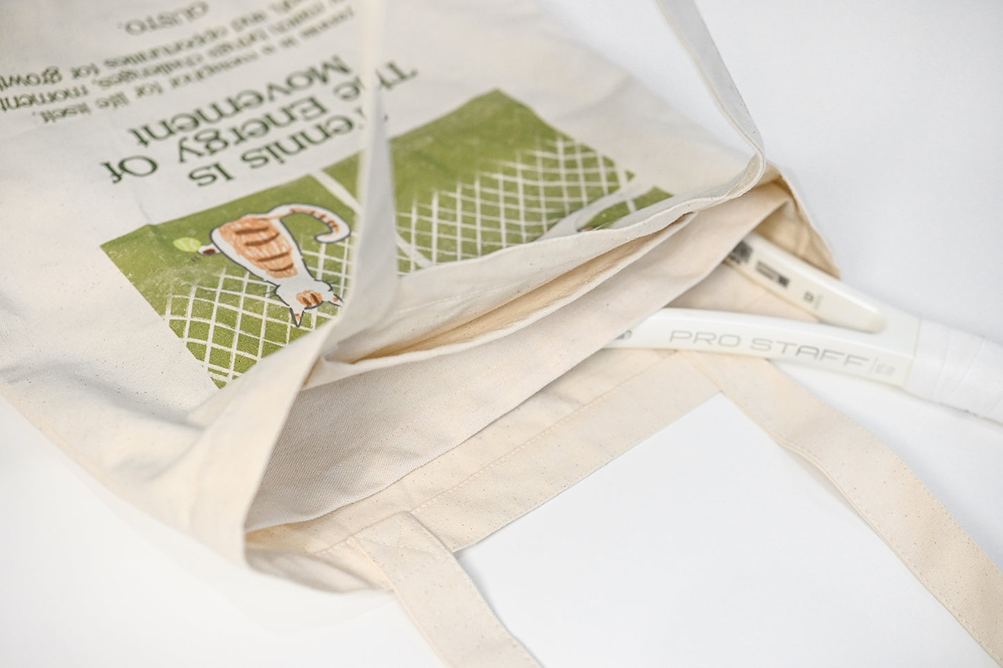 Main divider detail of tennis canvas tote bag, showing compartment for separating tennis racket and other items