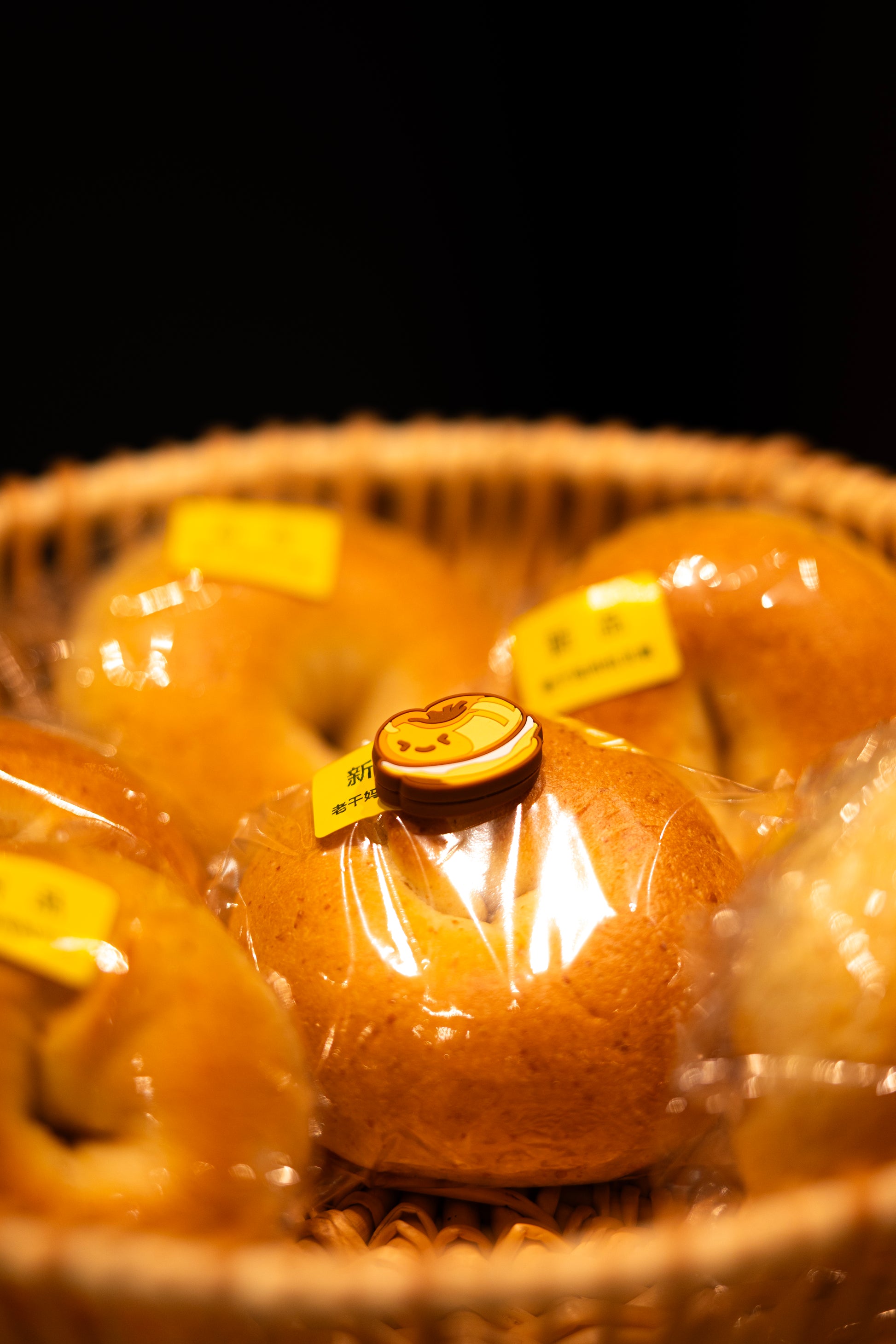 Close-up of bagel shaped tennis vibration dampener placed on real bagel bread, bakery series tennis accessory