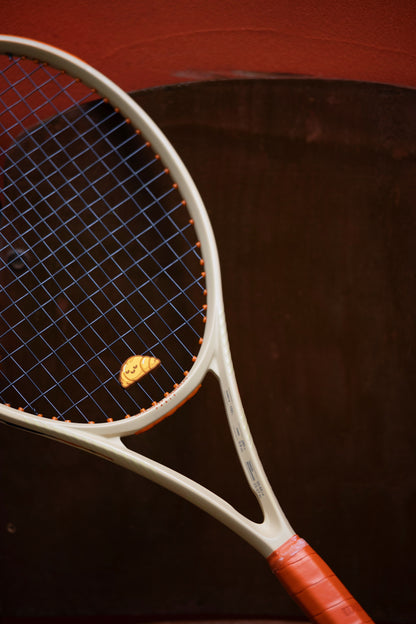 croissant dampener on racket during tennis match