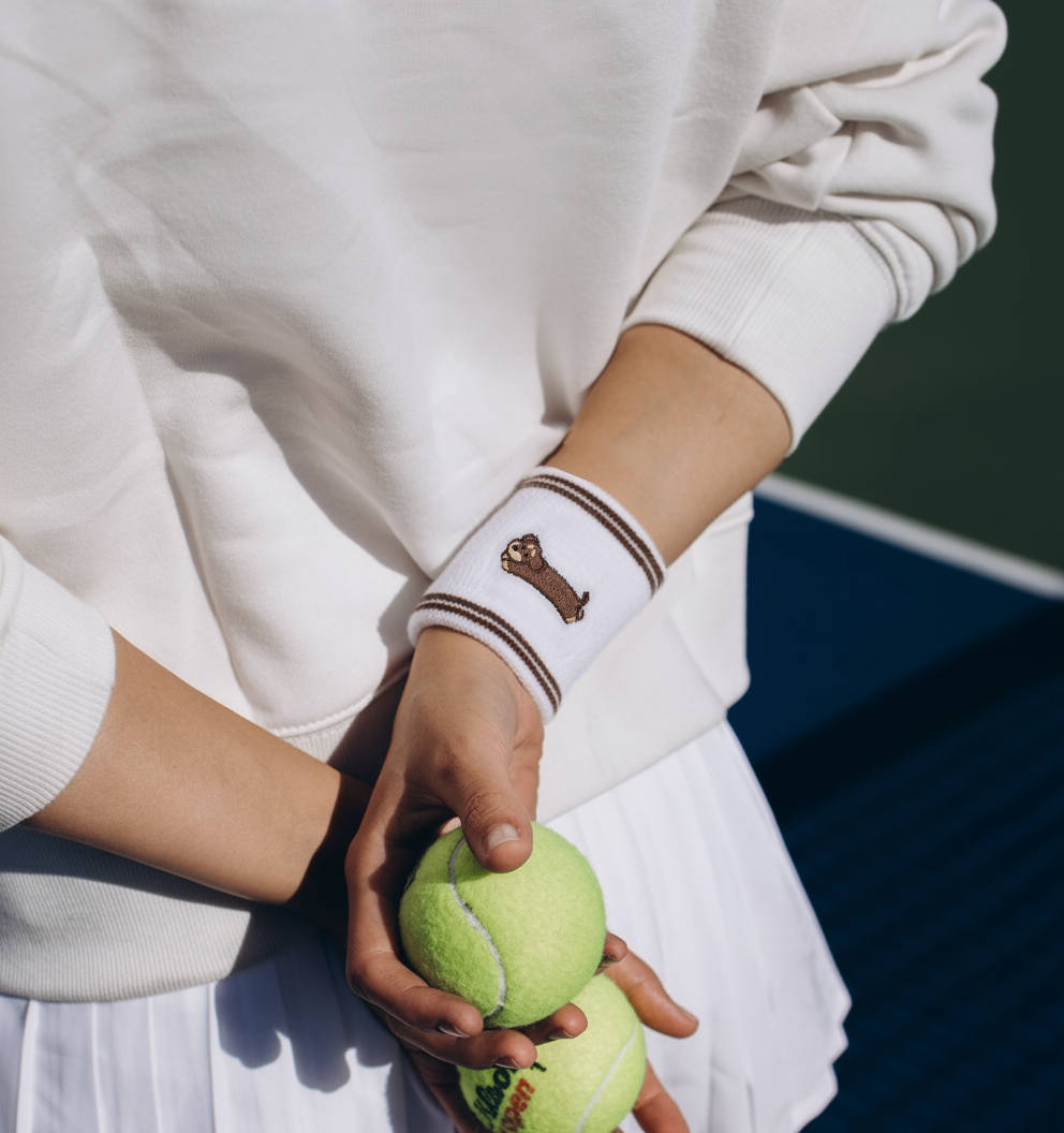 Close-up of model showing white terry cotton wristband with embroidered dachshund dog design