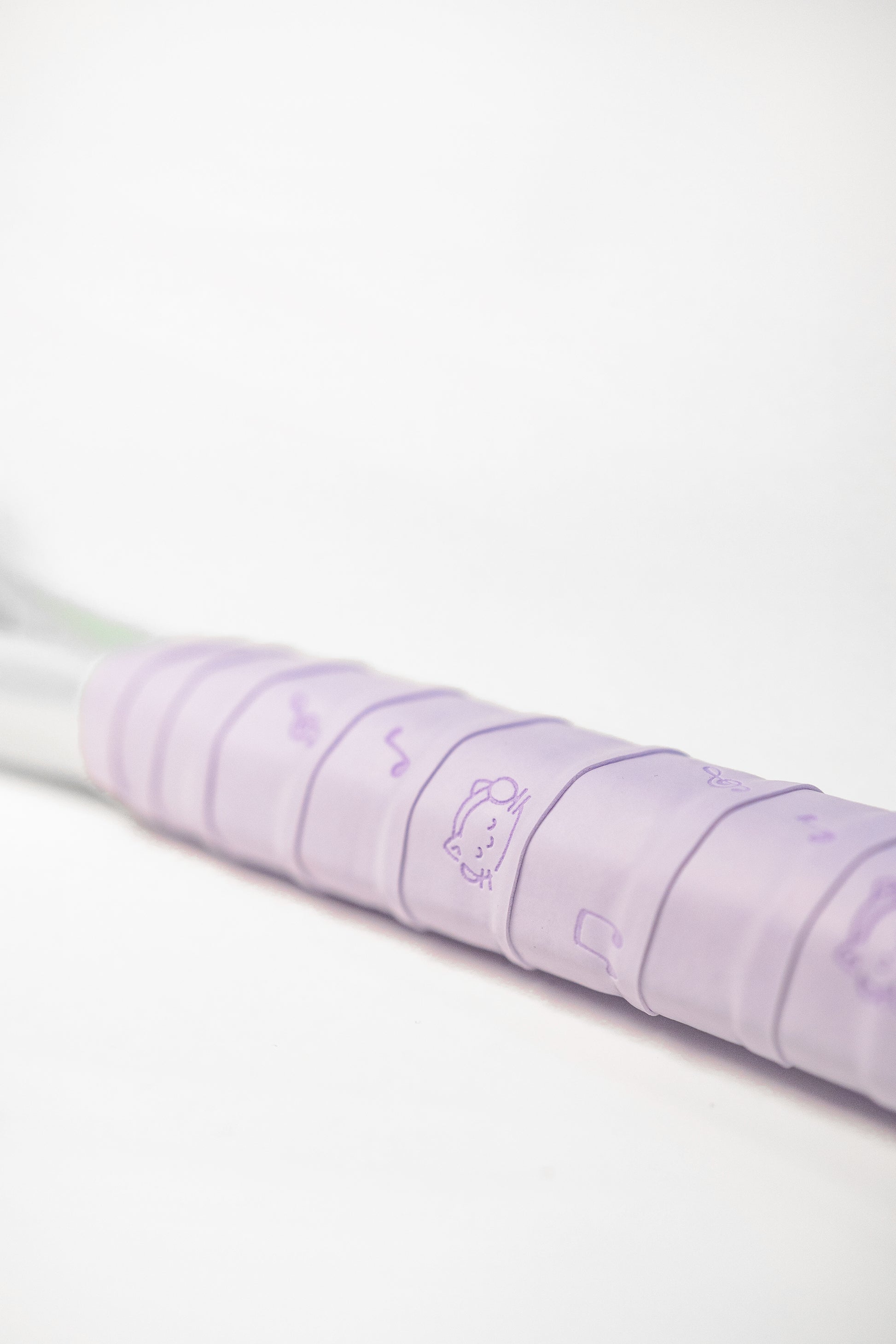 Purple racket grip with playful cat and music note pattern, sticky PU surface.